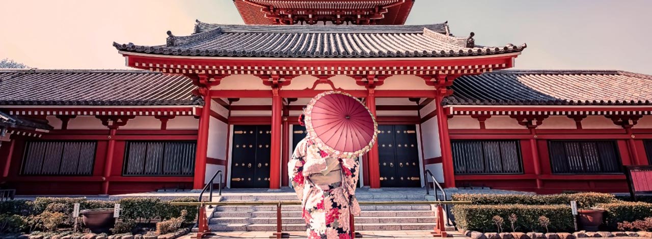 Woman in traditional; dress in front of the Senso-ji Temple in Tokyo