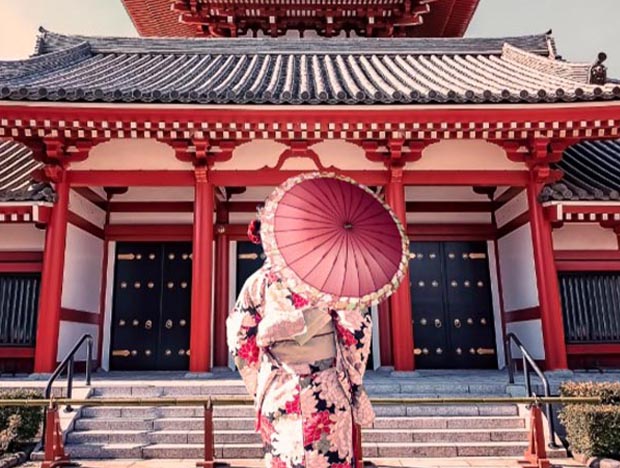 Woman in traditional; dress in front of the Senso-ji Temple in Tokyo